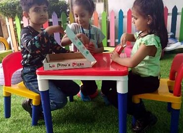 Pre-primary children at a pizza-shop role-play