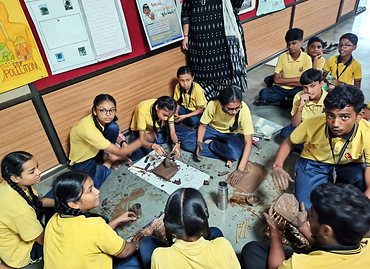Students shaping clay models in an art activity