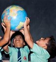 Students holding up a globe together