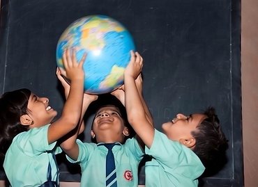 Students holding up a globe together